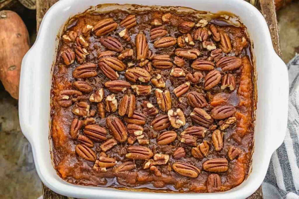 Homemade sweet potato casserole with a layer of pecans and rich glaze