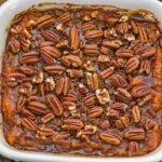 Homemade sweet potato casserole with a layer of pecans and rich glaze